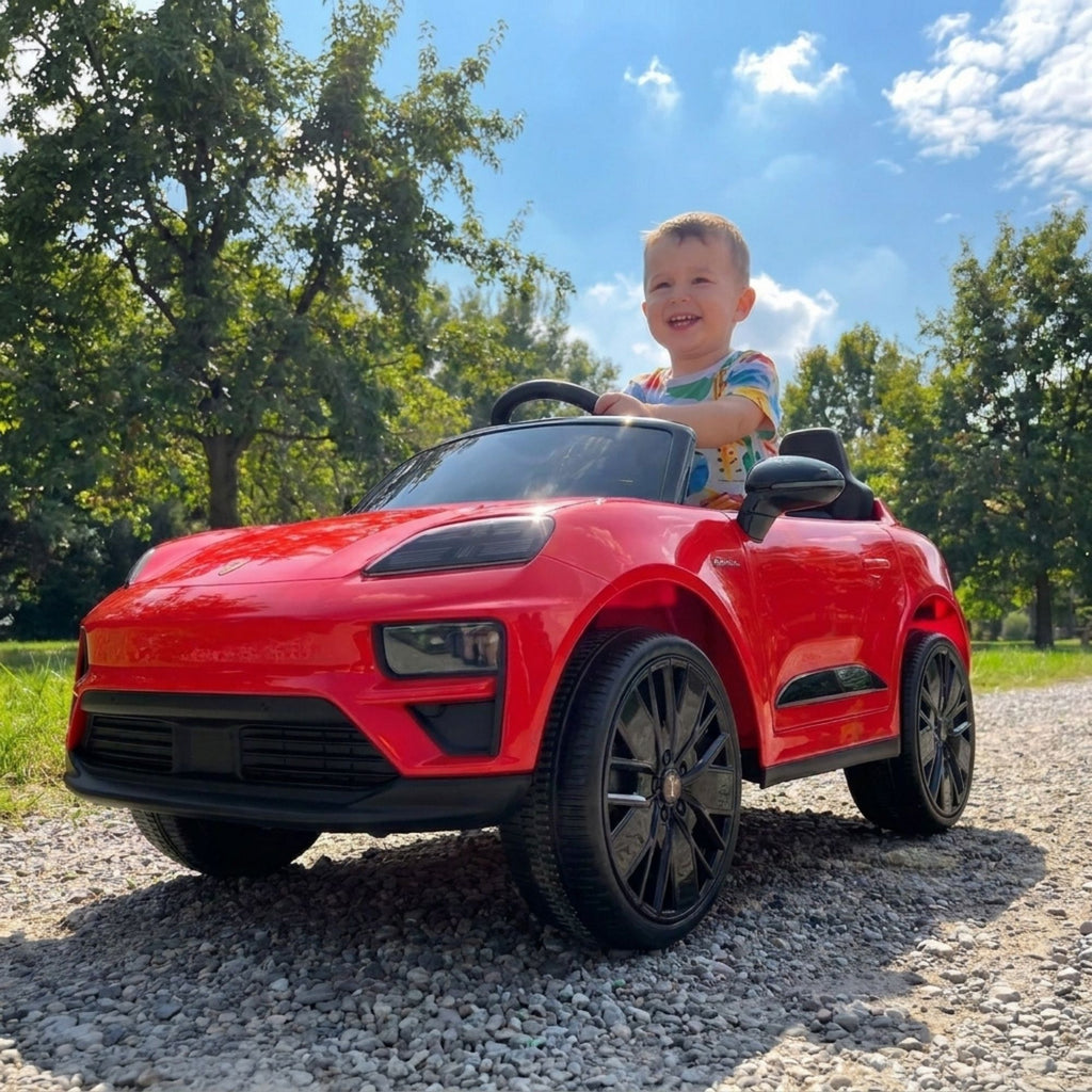 Porsche Macan rouge - enfant au volant dans un parc