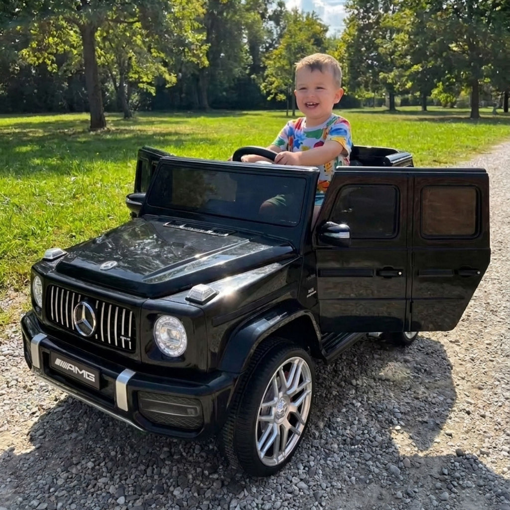 Mercedes G63 AMG noire - enfant au volant dans un parc
