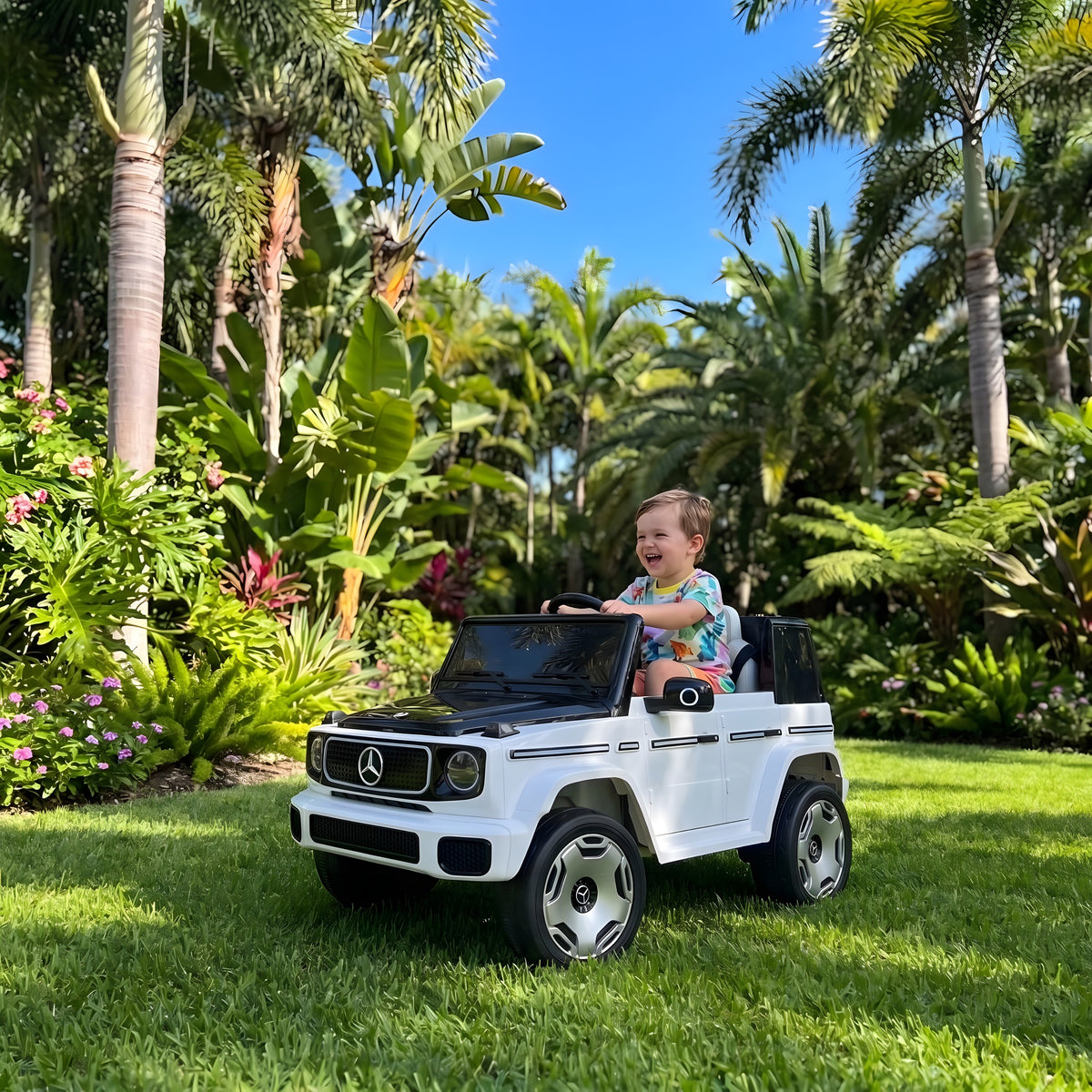 Enfant au volant du Mercedes EQG électrique dans un jardin