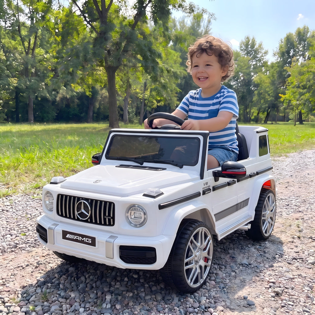 Enfant au volant du Mercedes G63 AMG blanc électrique dans un parc