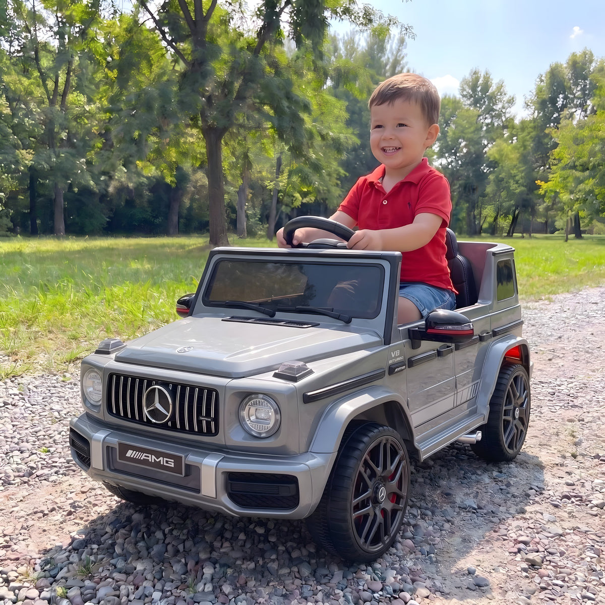 Enfant au volant du Mercedes G63 AMG gris électrique dans un parc
