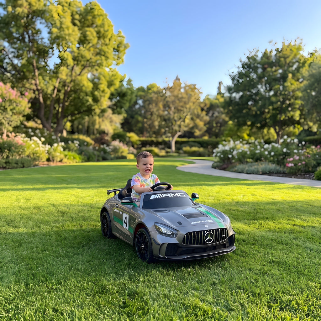 Enfant au volant de la Mercedes GT4 AMG électrique dans un jardin