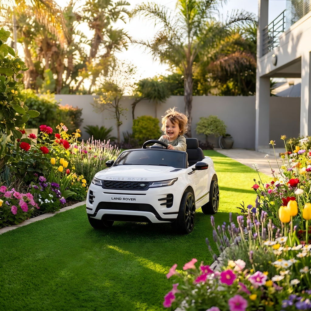 Enfant au volant du Range Rover Evoque blanc électrique dans un jardin