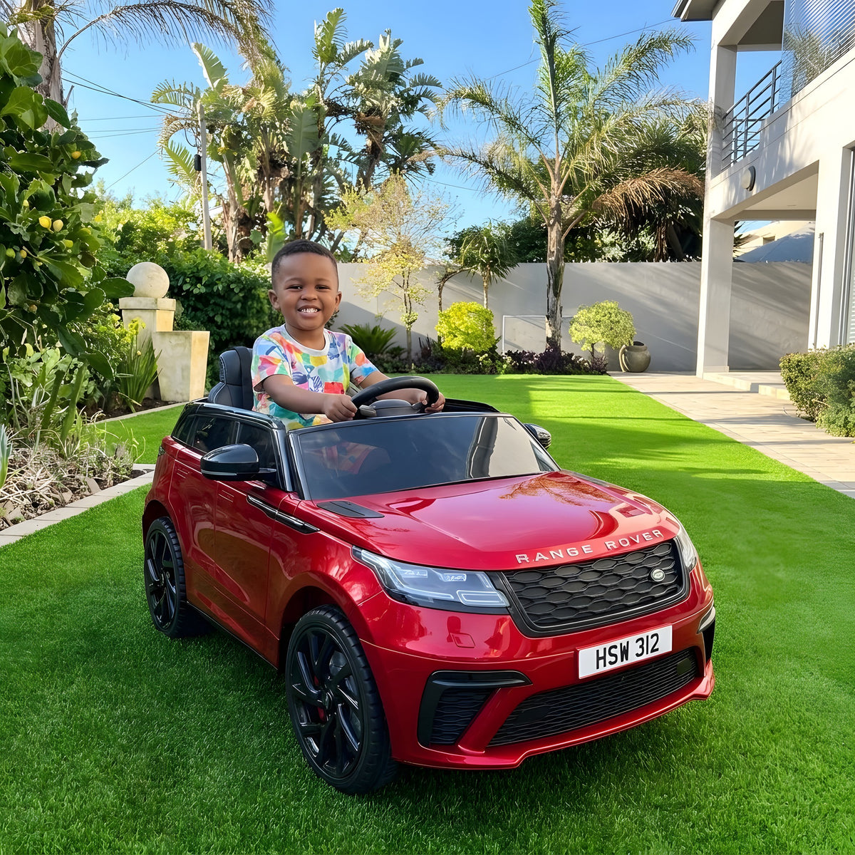 Enfant au volant du Range Rover Velar rouge électrique